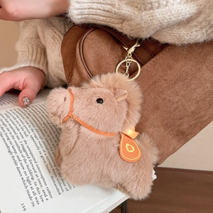 Dettaglio portachiavi a forma di cavallo in peluche con anello su borsa di camoscio
