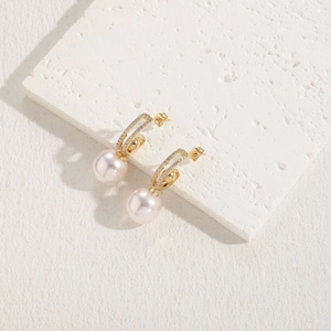Détail d'une boucle d'oreille perle rose avec zircones et placage en or 14K sur laiton