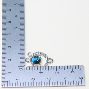 Macro shot of silver crescent moon pendant with blue galaxy stone and size scale