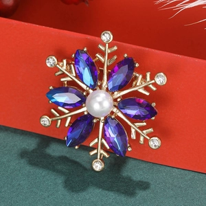 Macro shot of snowflake brooch with purple crystals and central pearl on festive gift box