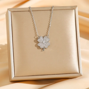 Titanium steel four-leaf clover necklace with sparkling cubic zirconia on a silk background
