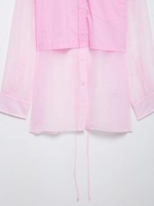 Dettaglio camicia rosa a maniche lunghe con inserti in organza e orlo con coulisse regolabile