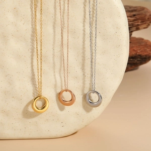 Three minimalist circle pendant necklaces in gold, rose gold and silver on stone