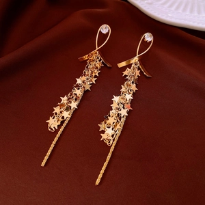 Detailed close-up of gold star fringe chain earrings with sparkling zircons and tassels