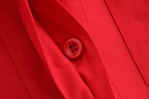 Macro view of high-density red poplin fabric texture with matching four-hole round button