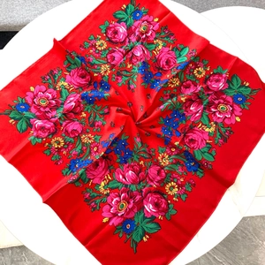 Detailed pattern of a red folk-style floral square scarf with pink roses and green leaves
