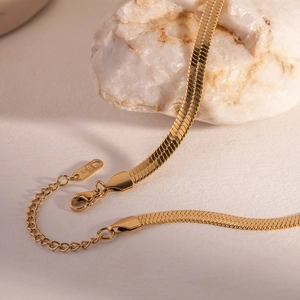 Close-up of 18K gold plated snake chain with K18 engraved tag and lobster clasp