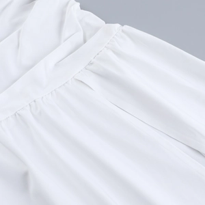 Détail de la robe d'été blanche montrant les fronces et les coutures sur tissu léger