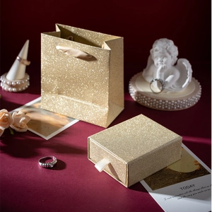 Close-up of luxury gold glitter gift bag and matching slide-out jewelry drawer box