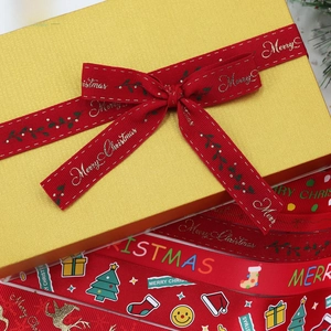 Close-up of red Christmas ribbons with gold Merry Christmas lettering and festive patterns