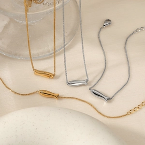 Elegant gold and silver fish pendant necklaces and bracelets set with subtle stone eyes