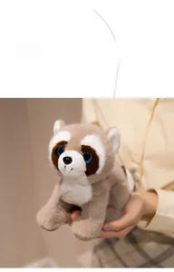 Close-up of raccoon plush toy with soft grey fur, blue sequin eyes, and circular toy tag
