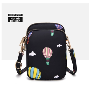 Detail of black crossbody phone bag featuring colorful hot air balloons and golden zippers