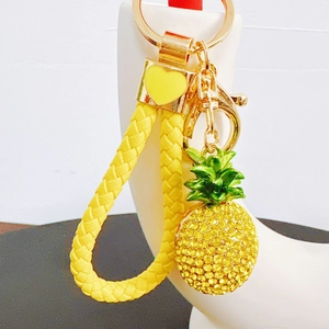 Close-up of a sparkling pineapple keychain with yellow rhinestones and gold-plated hardware