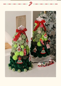 Close-up of decorative Christmas tabletop trees made of green plush pom-poms with ribbons