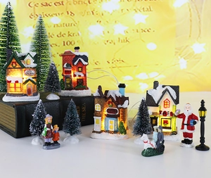 Macro shot of glowing Christmas miniature village with LED houses and snowy trees