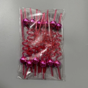 Pink disco mirror ball straws packaged in plastic wrap on a neutral surface