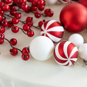 Close-up of red and white Christmas ornaments set with candy swirls and berries