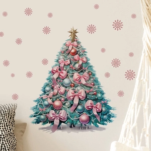 Detail of Christmas tree wall sticker with pink bows and golden star on a cream wall
