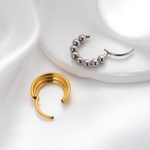Silver and multi-layer gold stainless steel seamless rings on white silk background