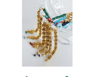 Macro detail of bohemian braided gold chain bracelets with colorful natural stone beads