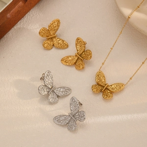 18k gold plated stainless steel butterfly earrings and necklace set on a beige surface
