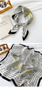 Detail of square silk scarf showing black stripes and yellow floral patterns