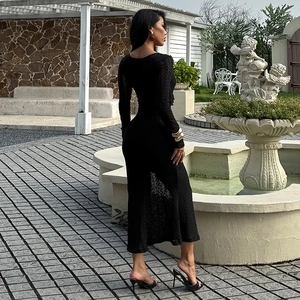 Détail de la texture et coupe ajustée d'une robe mi-longue en maille noire au soleil