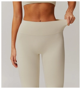 Detail of high-waist yoga leggings showing elastic tummy control fabric in beige