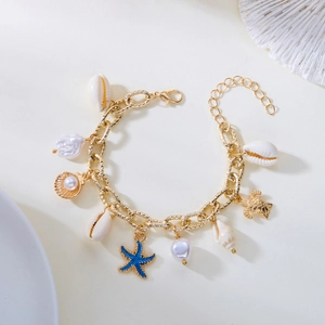 Bohemian gold chain bracelet featuring white shells, pearls, and blue starfish charms