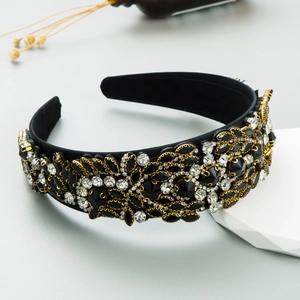 Close-up of luxury Baroque headband with black rhinestones and gold leaf textures