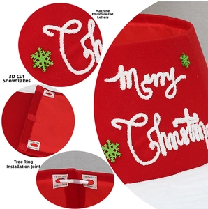 Detail of red Christmas tree skirt with Merry Christmas embroidery and snowflake patches