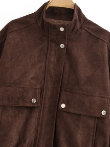 Detail of brown faux suede jacket featuring silver metal snap buttons and chest pockets