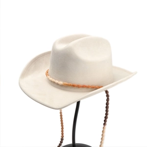 Détail d'un chapeau de cowboy en daim blanc avec perles orange et une mentonnière perlée