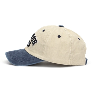 Close-up of vintage washed baseball cap with contrast navy brim and side letter embroidery