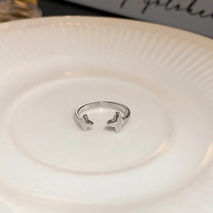 Macro view of adjustable silver star ring with polished four-pointed stars on a white tray