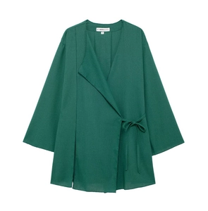 Detail of dark green wrap-around linen top with long sleeves and fabric texture