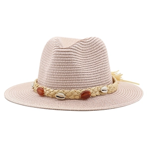Close-up of handwoven fedora straw hat with natural shells and beaded tassel detail