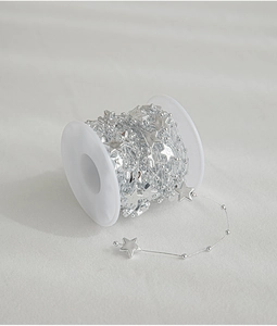 Detail of silver five-point star beaded chain on a roll for Christmas DIY decoration