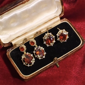 Detailed macro view of 18K gold plated jewelry set with red oval zircon in vintage box