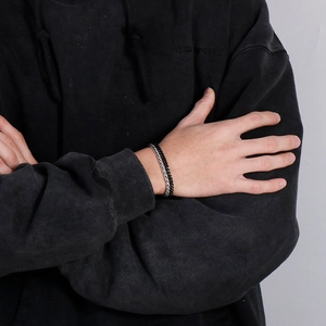Macro view of men's punk double-strand woven titanium steel bracelet on wrist