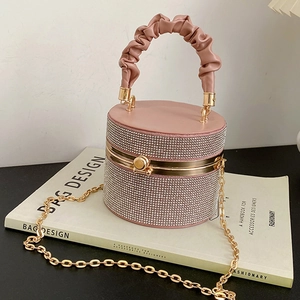 Sparkling pink rhinestone cylinder handbag with pleated handle on a fashion book