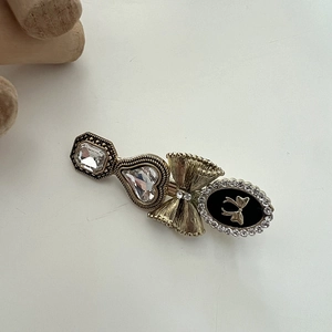 Detailed view of vintage gold hair clip with crystal hearts and black enamel butterfly bow