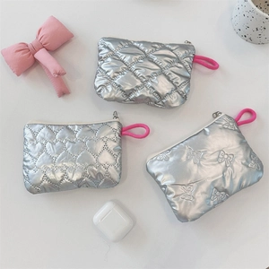 Detail of silver quilted pouches with heart and diamond patterns and pink zipper pulls