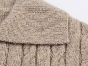 Detailed view of cable knit pattern and large collar on beige long sleeve knit polo sweater