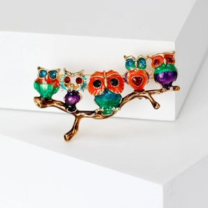 Detail view of five colorful owls on a branch brooch with vibrant enamel and rhinestones