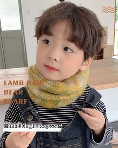 Close-up of yellow and green checkered knit scarf on child model in cozy setting