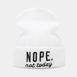 Gros plan du bonnet blanc en maille avec broderie noire 'NOPE. not today' stylée