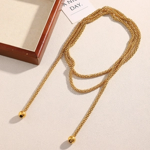 Close-up of 18K gold plated multi-layer bead chain necklace with ball pendants