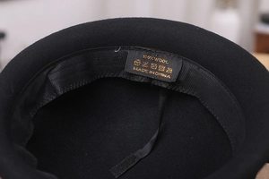 Détail de l'étiquette en laine 100% et du bandeau à l'intérieur du chapeau en feutre noir